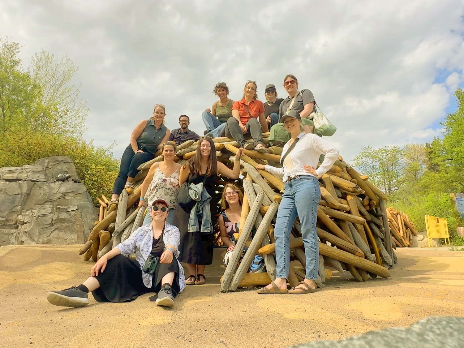 L’équipe de Fuse réunie sur une grande sculpture de bois, en plein air